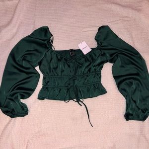 Brand new faux silk top. It’s emerald green, puff sleeve, and tie front!
